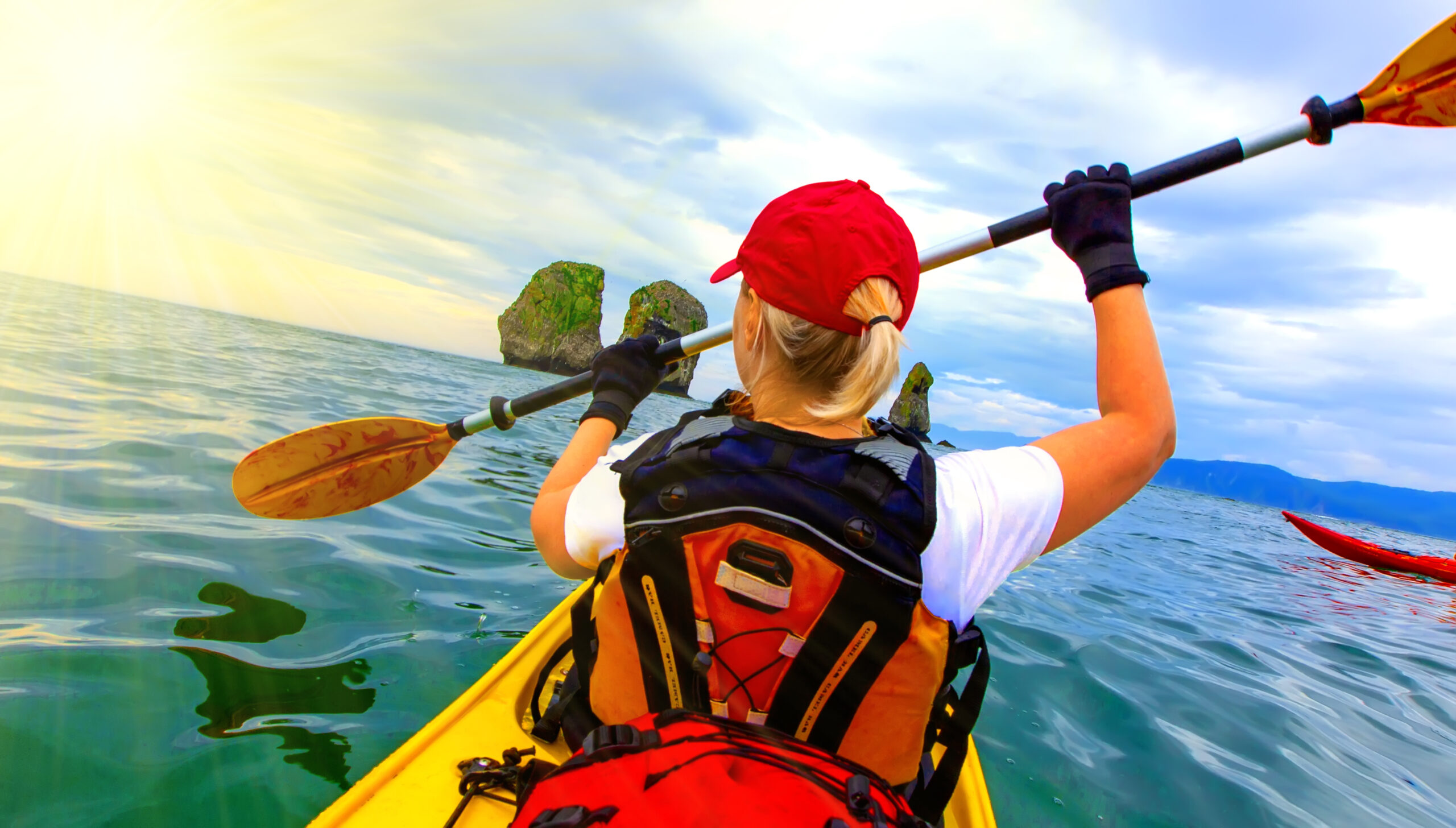 Woman paddles kayak on Pacific ocean